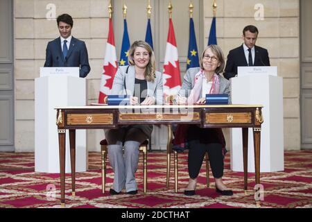 French President Emmanuel Macron (R) and Canadian Prime Minister Justin Trudeau (L) look as French Culture Minister Francoise Nyssen (2nd R) and Canadian Heritage Minister Melanie Joly (2nd L) sign an agreement at the Elysee Palace in Paris on April 16, 2018. Trudeau is on a two-day official visit to France. Photo by Eliot Blondet/ABACAPRESS.COM Stock Photo