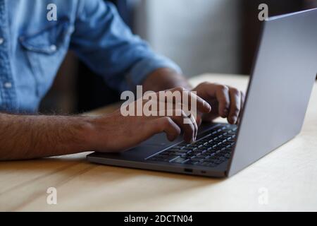 Close-up photo of male hands with laptop. Freelancer sitting on his workplace, texting message, searching web, browsing information using laptop Stock Photo