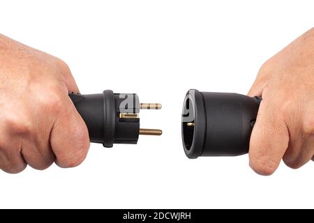 Two parts of an electrical plug in hands in the moment of connecting disconnecting