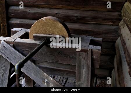 Antique grinding stone in wood, iron and rock, made for sharpening knives and other metal tools. Stock Photo