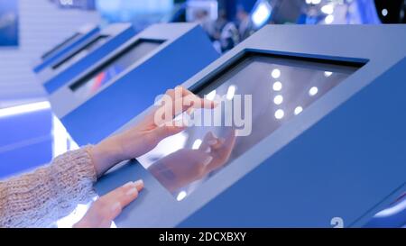 Woman using interactive touchscreen display at technology exhibition Stock Photo