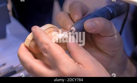 Dental technician working with dental prosthetics - close up view Stock Photo