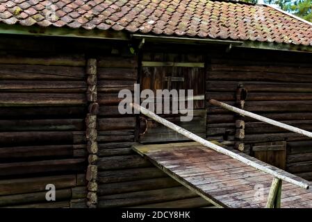 Abandoned old Nordic barn with a wagon bridge. Made from old timber planks and logs and looks weathered. Stock Photo