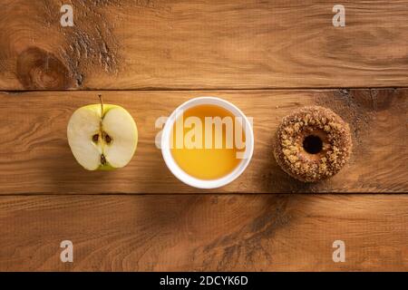 One homemade baked apple cider donut, cider and apple on natural wooden table. Ready to eat snack. Homemade food with ingredients. Directly above view Stock Photo