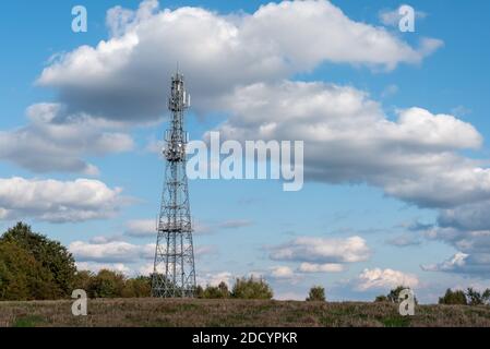 Telecommunication Tower Against Cloudy Blue Sky Stock Photo