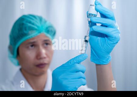 Doctor's hands fill syringe with medicine vial on hands of a nurse,doctor preparing administer injection to the patient. medicine concept