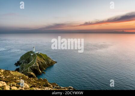 Lighthouse on coastal island with horizon and beautiful sunset at South Stack in Holyhead, North Wales. Stock Photo