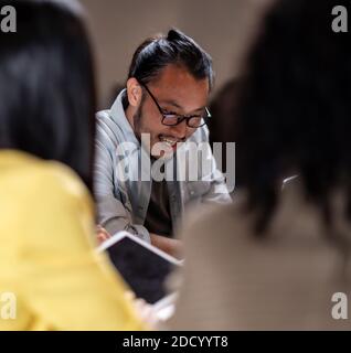Portrait of Asian businessman working late having meeting with business team to brainstorm idea at office meeting room. Work hard deadline and overtim Stock Photo