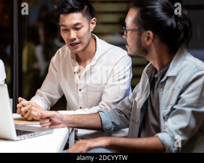 Portrait of Asian businessman working late having meeting with business team to brainstorm idea at office meeting room. Work hard deadline and overtim Stock Photo