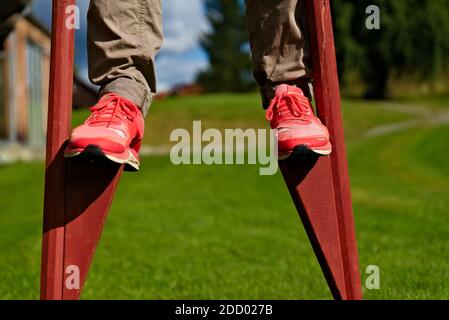 Person walking on traditional stilts in a park Stock Photo