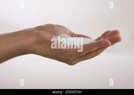 Hand holding white polystyrene foam beads ball drop Stock Photo
