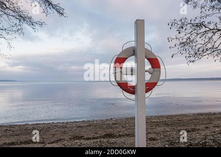 lifebuoy hanging on a pole on the shore close to the sea, Hvidbjerg, Denmark, November 15, 2020 Stock Photo