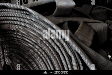 Fire fighter hose rolled up and ready for action. Close-up. Stock Photo