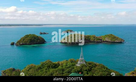 Seascape with a cluster of tropical Islands in turquoise water, aerial seascape. Hundred Islands National Park, Pangasinan, Philippines. Famous tourist attraction, Alaminos. Summer and travel vacation concept