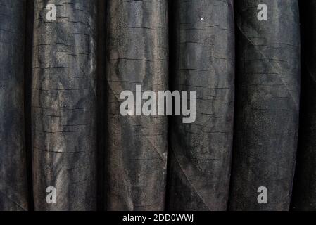 Cracked worn rubber hoses in a coil. Close-up. Stock Photo