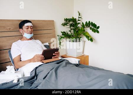 Sick man lying in bed Stock Photo