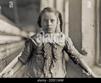 LEWIS HINE (1874-1940) American sociologist and photographer.  Girl working in a Carolina Cotton Mill in 1908. Stock Photo