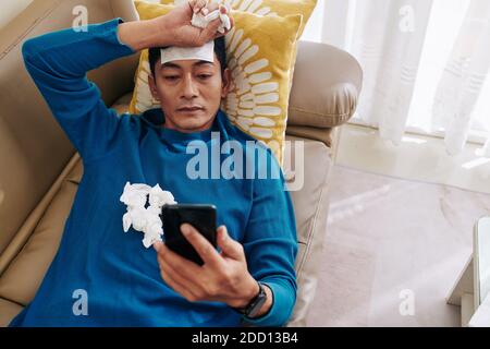 Sick man resting on sofa Stock Photo