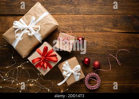 Christmas presents covered with craft paper on a wooden background, top view. Winter holidays concept Stock Photo