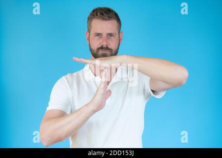 A man shows the hands stop timeout over blue background Stock Photo