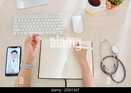 General practitioner taking notes in planne Stock Photo