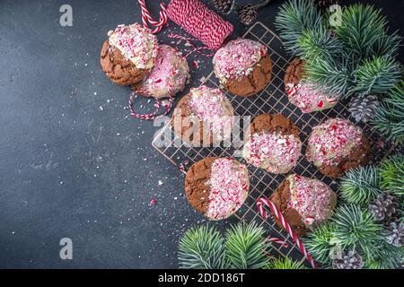 Homemade  chocolate cracked brownie cookies dipped in white chocolate and candy cane bits. Idea recipe for Christmas party treats, winter holiday food Stock Photo