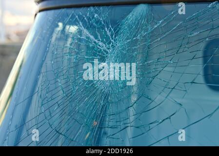 Broken windshield window on a car after getting smashed with a rock.  Stock Photo