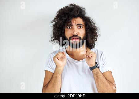 scared frightened male look at camera, guy of arabic appearance in casual white t-short Stock Photo