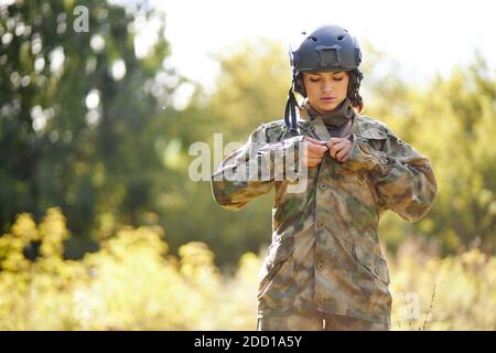serious soldier woman wearing jacket in the forest, she is going to hunt Stock Photo