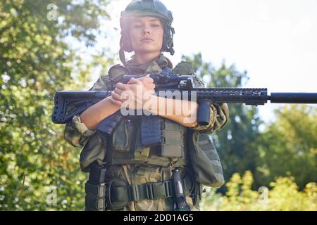 strong brave female army soldier with rifle machine gun standing in the ...