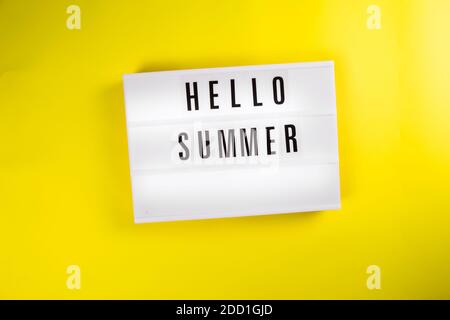 Hello Summer text message on lightbox on yellow background isolated flat lay Stock Photo