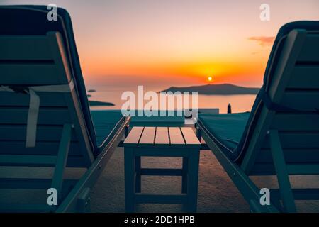 Infinity pool on the rooftop at sunset in Santorini Island, Greece. Beautiful poolside and sunset sky. Luxurious summer vacation and holiday concept, Stock Photo