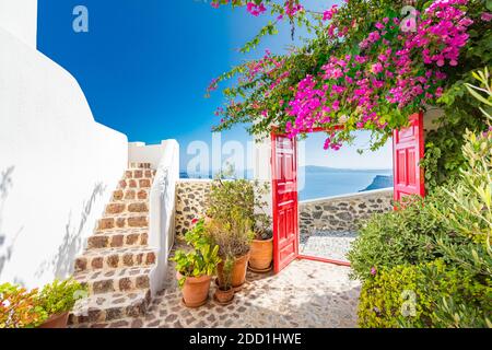 Fantastic travel background, Santorini urban landscape. Red door or gate with stairs and white architecture under blue sky. Idyllic summer vacation Stock Photo