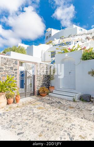 Scenic view of traditional cycladic Santorini houses on small street, old stone path, white architecture and blue sky. Summer travel vacation, idyllic Stock Photo