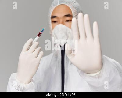 A man of Asian appearance holds a hand in front of him vaccination research laboratory Stock Photo