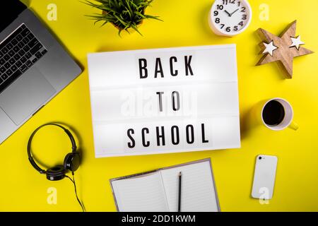 Back to school text on lightbox on modern yellow office work table Stock Photo