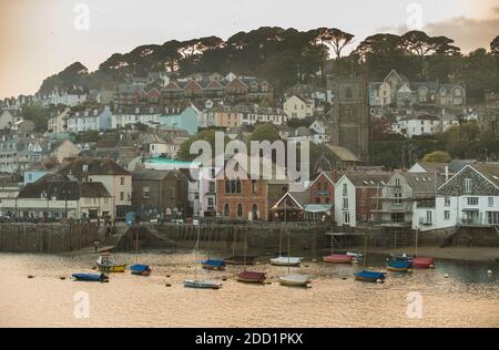 Small boats are anchored in front of the small coastal town of Fowey, Cornwall, England. Stock Photo