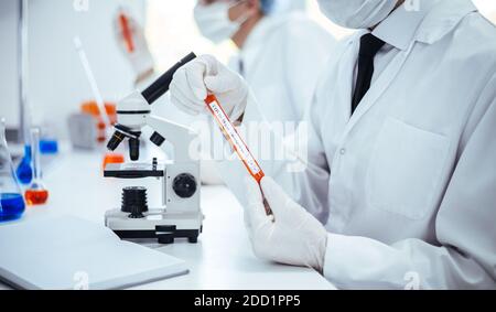 close up. scientist reading the inscription on the tube with the test. Stock Photo