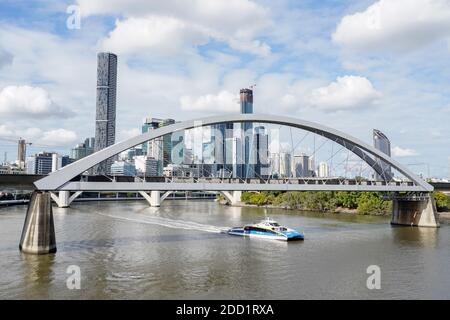 CityCat on Brisbane River, passing under train bridge in Brisbane city. Skyline of Central Business District in background. Stock Photo
