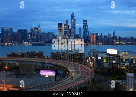 Twilight view of the skyline of Midtown Manhattan in New York City with Hudson River and the traffics on Lincoln Tunnel Helix Loop in Weehawken New Jersey in foreground.NJ.USA Stock Photo