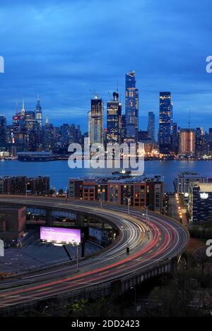 Twilight view of the skyline of Midtown Manhattan in New York City with Hudson River and the traffics on Lincoln Tunnel Helix Loop in Weehawken New Jersey in foreground.NJ.USA Stock Photo