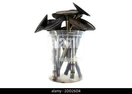 Old crooked motor valves standing in a plastic container shaped like a bouquet of flowers, isolated on a white background. Stock Photo