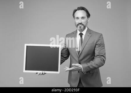 Product introduction. Businessman presenting product at blackboard. Product promotion. Product advertising. Promoting and marketing. Sale. Shopping. Special offer. Place the order, copy space. Stock Photo