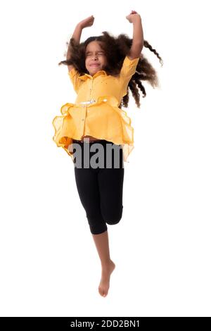 Multiracial small girl jumping with her eyes closed and a funny expression- Isolated on a white background Stock Photo
