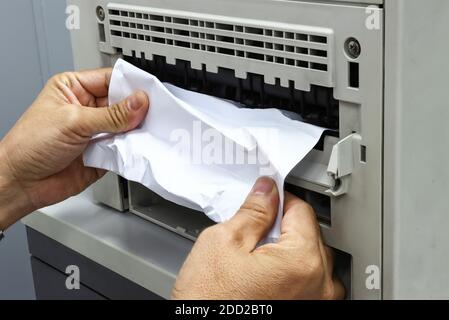 Technicians Removing Paper Stuck, Paper Jam In Printer At Office Stock Photo