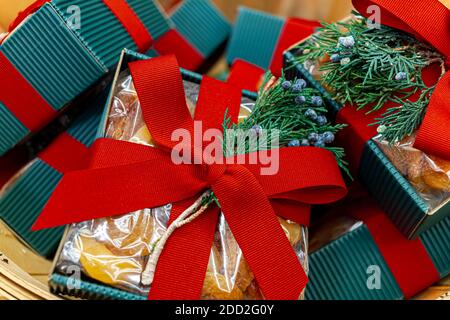 Close up isolated image of a pile of christmas gifts  each put on blue square boxes and wrapped with red ribbons. Each have a piece of fir with blue c Stock Photo
