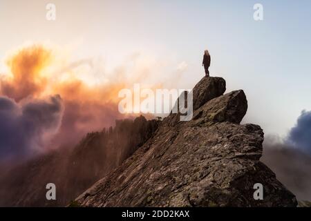 Adventurous Girl on top of a Mountain Peak Stock Photo
