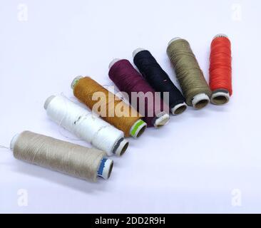 Old vintage hand sewing machine Colored thread coils or bobbin on white background, sewing machine accessories. selective focus. image Stock Photo