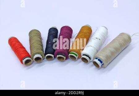 Old vintage hand sewing machine Colored thread coils or bobbin on white background, sewing machine accessories. selective focus. image Stock Photo