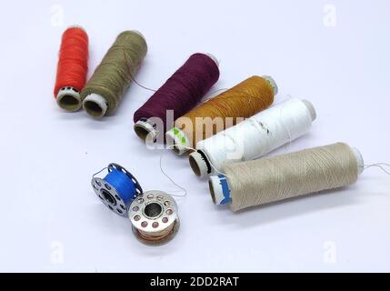 Old vintage hand sewing machine Colored thread coils or bobbin on white background, sewing machine accessories. selective focus. image Stock Photo